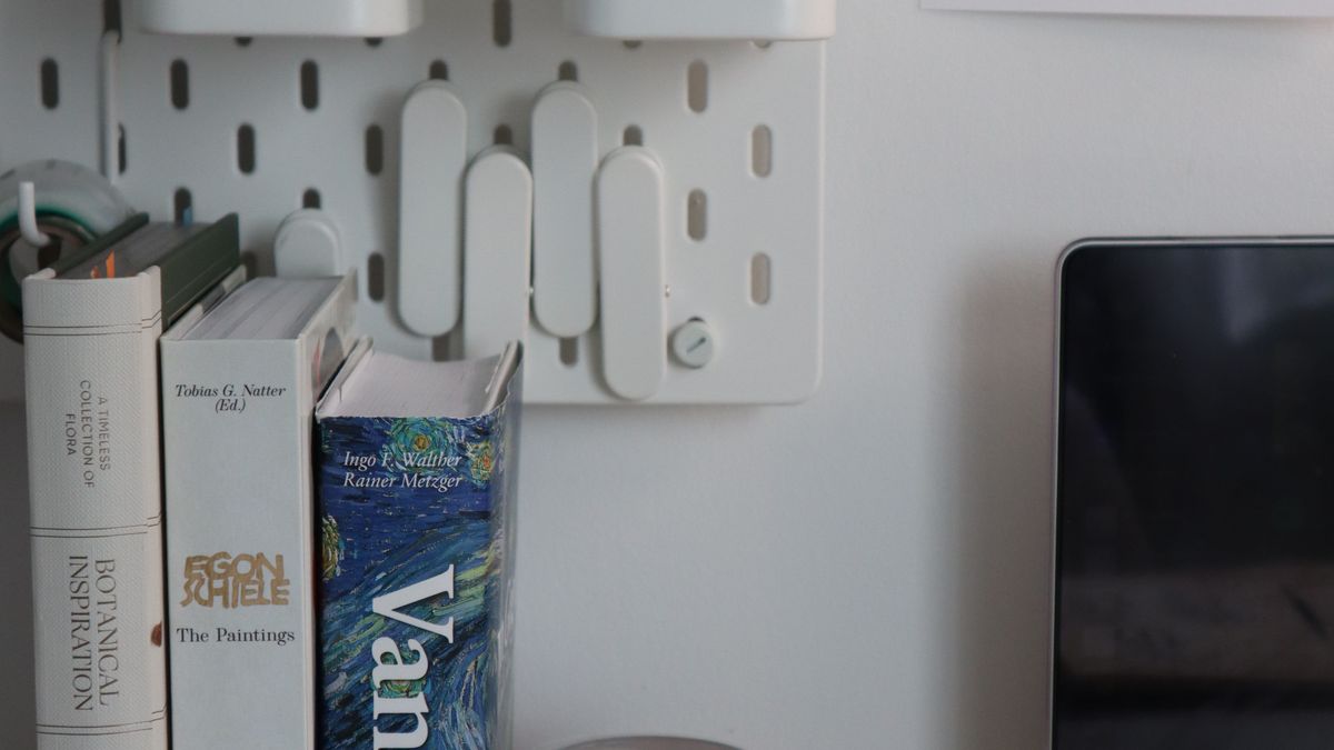 A clean, organised home-office desk with a laptop, notebook, and tidy stationery